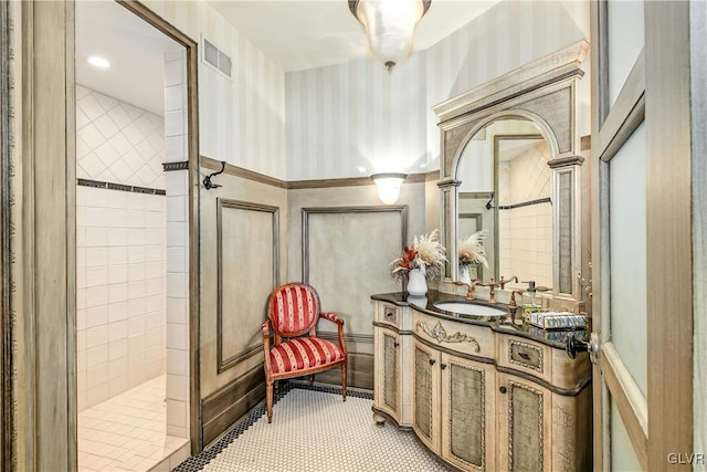 bathroom featuring a tile shower, vanity, and tile patterned floors