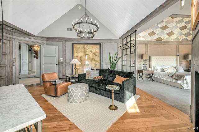 living room with beam ceiling, light hardwood / wood-style flooring, high vaulted ceiling, and a notable chandelier