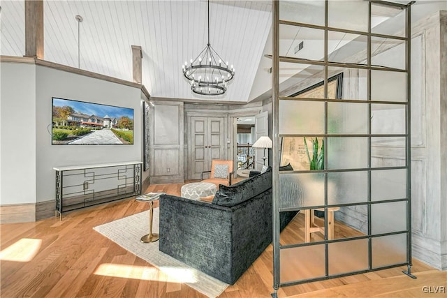 interior space with a chandelier, vaulted ceiling, and hardwood / wood-style flooring