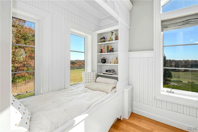 bedroom with wood-type flooring and multiple windows