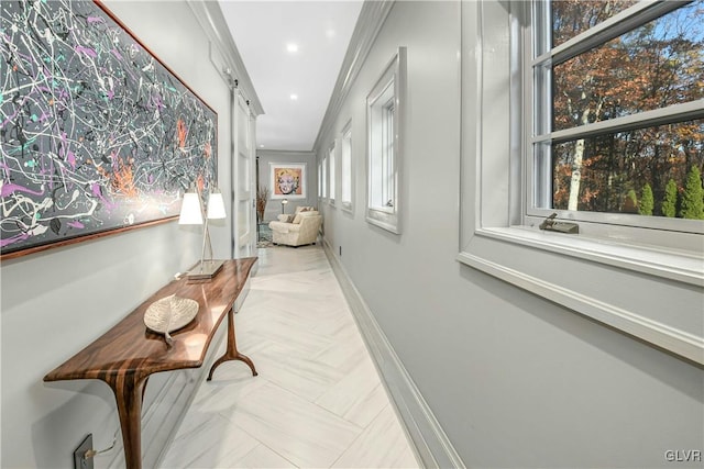 corridor with a barn door and ornamental molding