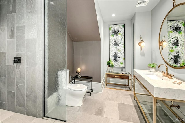 bathroom featuring a tile shower, vanity, and toilet