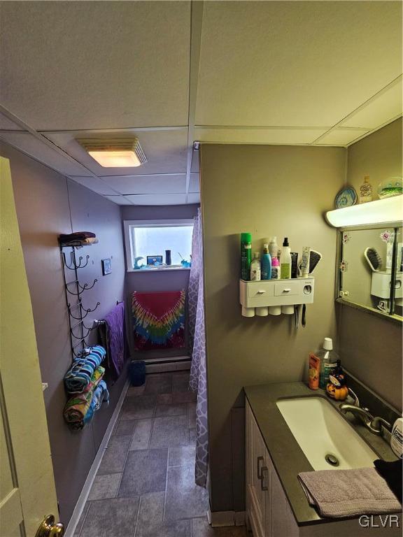 bathroom featuring vanity and a drop ceiling