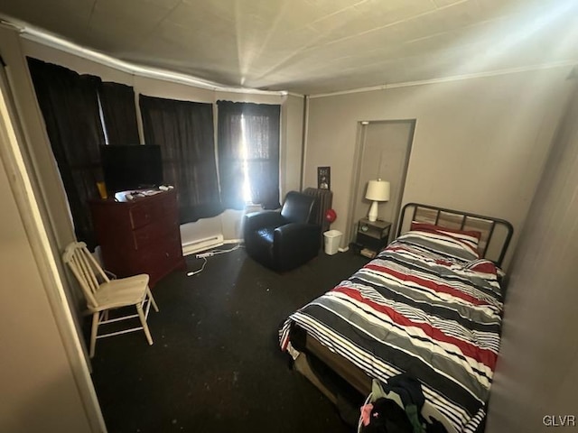 bedroom with concrete flooring and a baseboard heating unit