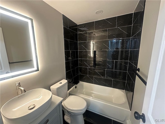 full bathroom with tiled shower / bath combo, toilet, and vanity