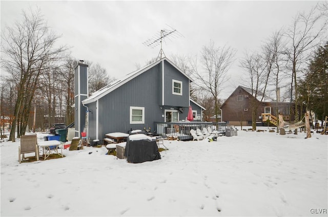 snow covered rear of property featuring a wooden deck