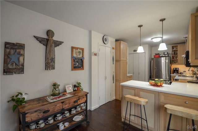 kitchen with a breakfast bar, hanging light fixtures, dark hardwood / wood-style floors, kitchen peninsula, and stainless steel appliances