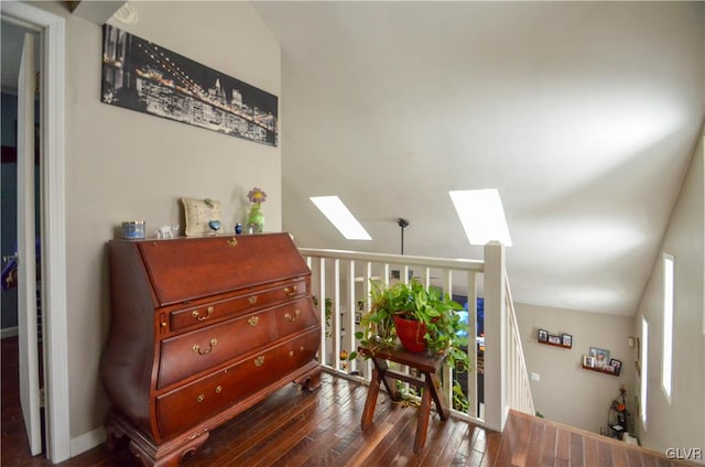 interior space featuring dark hardwood / wood-style flooring and vaulted ceiling with skylight