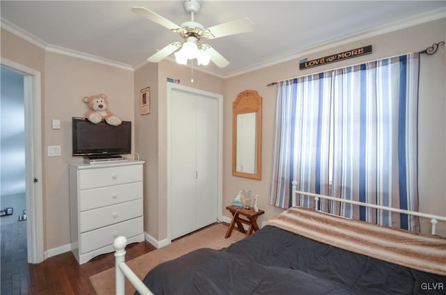 bedroom featuring ceiling fan, wood finished floors, baseboards, ornamental molding, and a closet