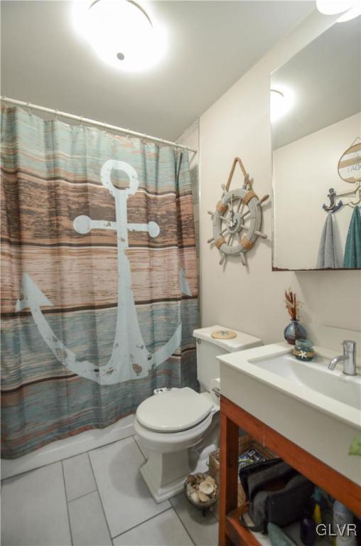 full bath with toilet, curtained shower, tile patterned flooring, and vanity