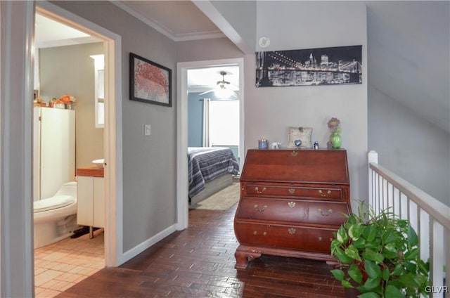 hall featuring ornamental molding, dark wood finished floors, and baseboards