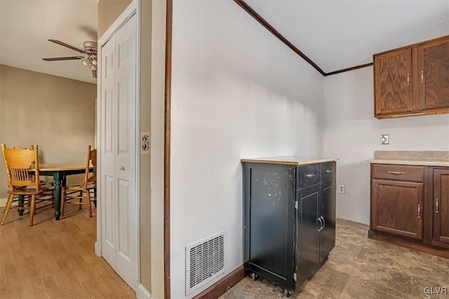 kitchen with ceiling fan, light wood-type flooring, and crown molding