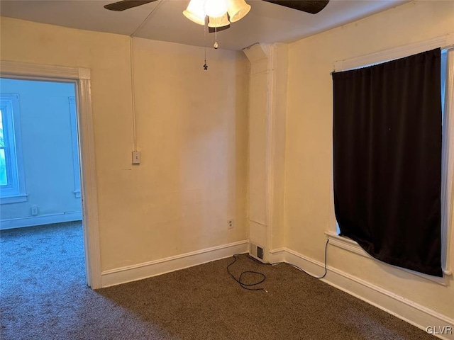 empty room featuring dark carpet and ceiling fan