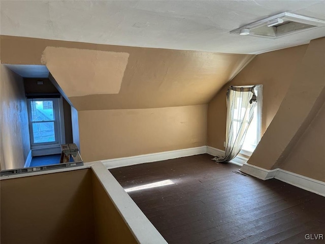 bonus room with dark hardwood / wood-style floors and vaulted ceiling