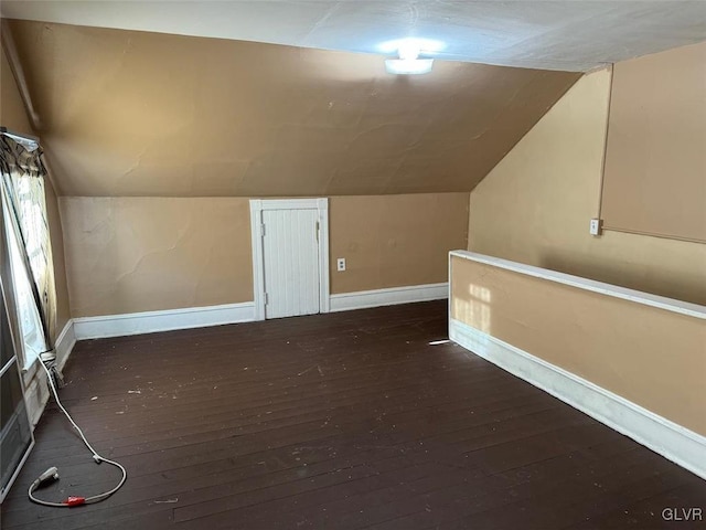 bonus room with dark wood-type flooring and vaulted ceiling