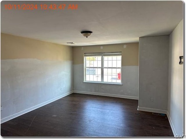 unfurnished room with dark wood-type flooring