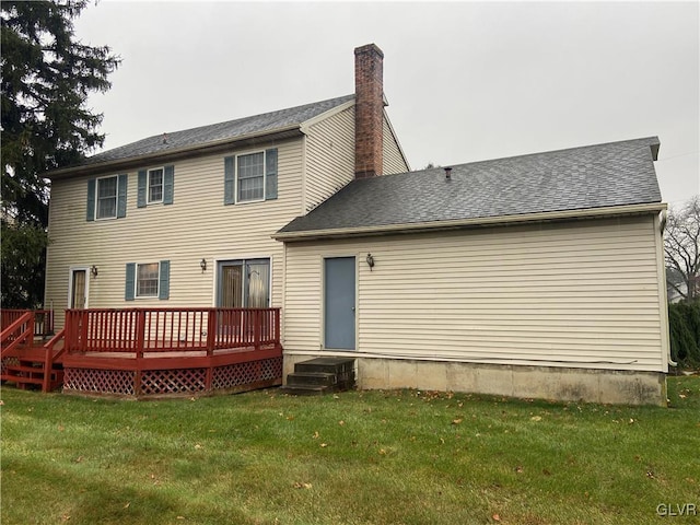 back of property featuring a wooden deck and a lawn