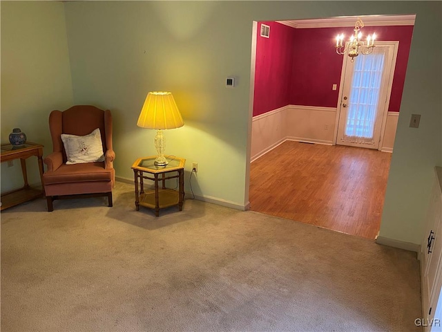 sitting room featuring a chandelier, wood-type flooring, and crown molding