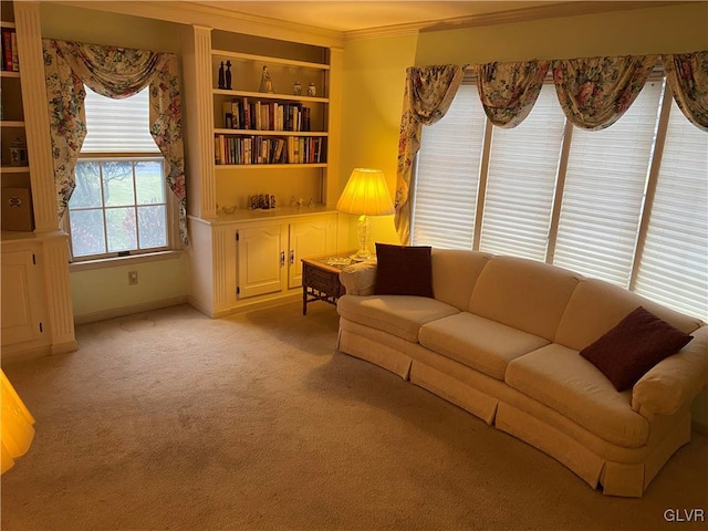 carpeted living room featuring built in shelves and ornamental molding