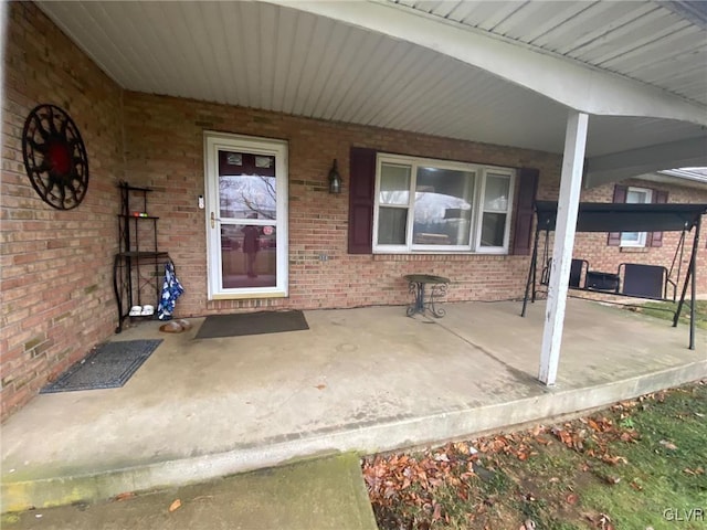 view of exterior entry featuring covered porch