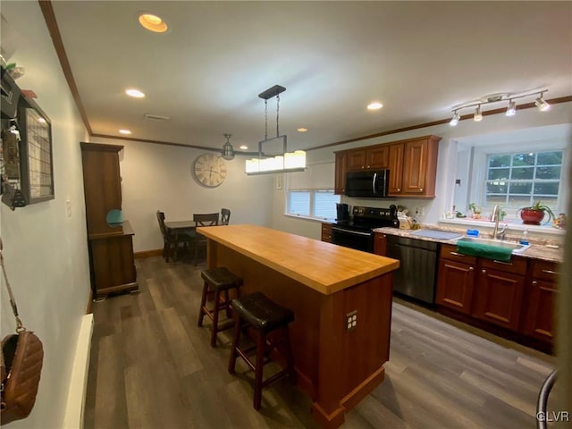 kitchen featuring a wealth of natural light, sink, black appliances, and dark hardwood / wood-style floors