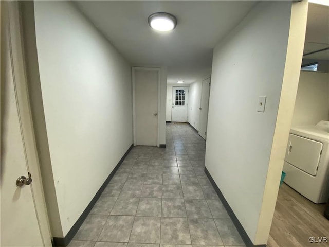 hallway with light tile patterned floors and washer / dryer