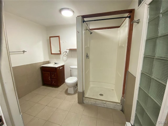 bathroom with tile patterned flooring, a shower, vanity, and toilet