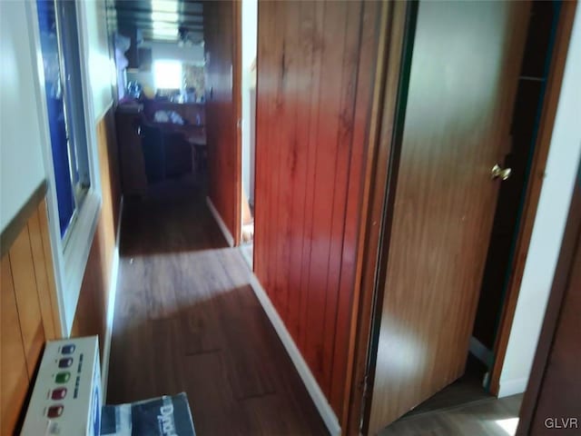 hallway with hardwood / wood-style floors and wood walls