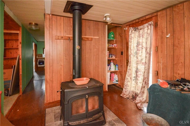 room details featuring a wood stove, wooden walls, and wooden ceiling