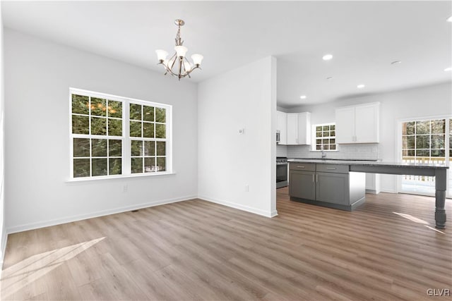 kitchen featuring light hardwood / wood-style flooring, white cabinetry, a wealth of natural light, and a kitchen island