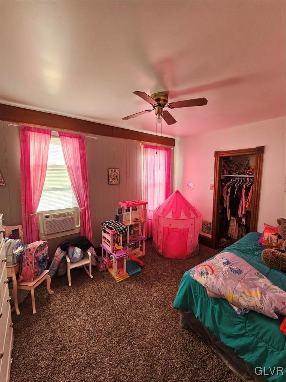 carpeted bedroom featuring ceiling fan, a closet, and cooling unit