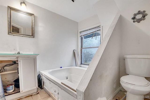 bathroom featuring tile patterned floors, toilet, and a tub