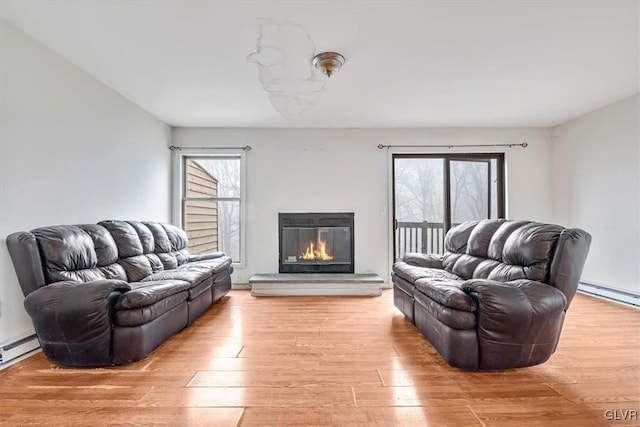 living room featuring a baseboard heating unit and light hardwood / wood-style flooring