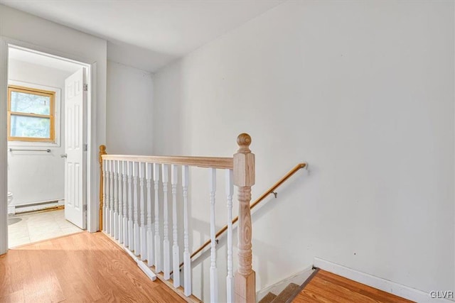 corridor with light wood-type flooring and a baseboard radiator