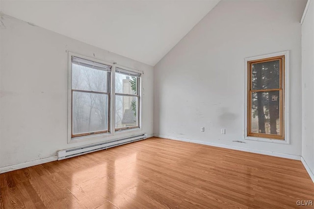 spare room with baseboard heating, high vaulted ceiling, and light hardwood / wood-style flooring