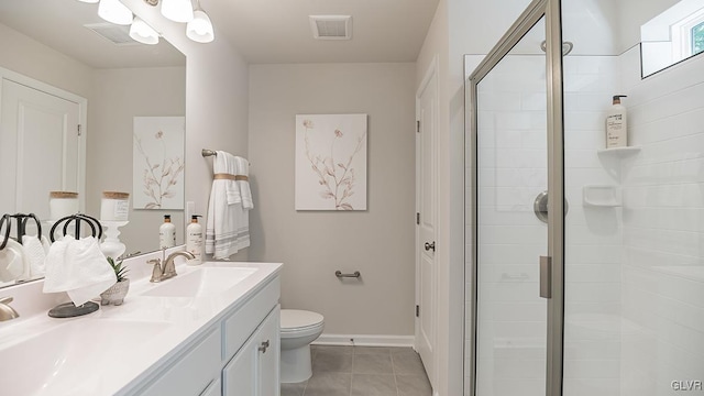 bathroom featuring tile patterned flooring, vanity, toilet, and a shower with door