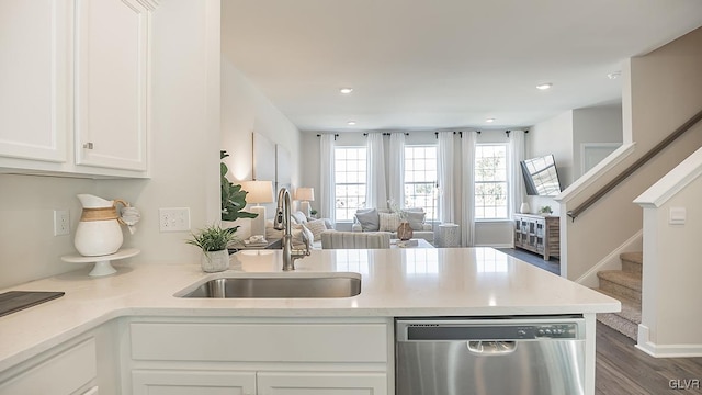 kitchen featuring kitchen peninsula, stainless steel dishwasher, sink, white cabinets, and dark hardwood / wood-style floors