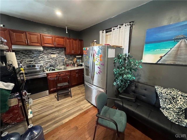 kitchen featuring tasteful backsplash, sink, stainless steel appliances, and light hardwood / wood-style floors