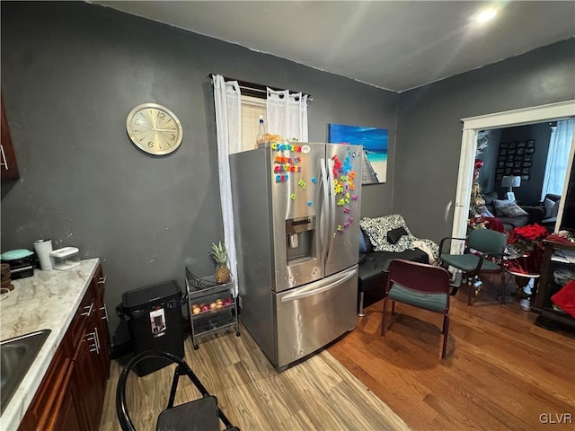 kitchen featuring light hardwood / wood-style floors, stainless steel fridge with ice dispenser, and sink