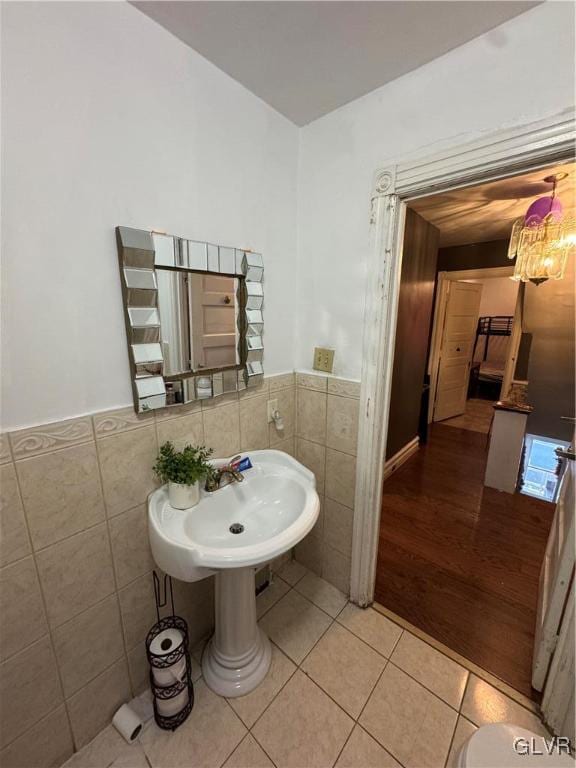 bathroom with hardwood / wood-style flooring, tile walls, and sink