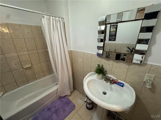 bathroom featuring tile patterned floors, shower / tub combo with curtain, tile walls, and sink