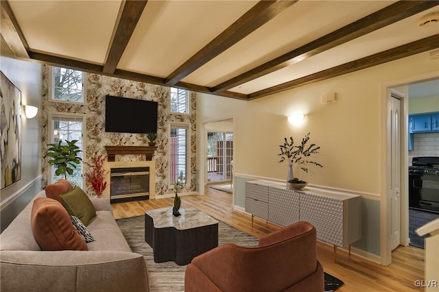 living room with a fireplace, light wood-type flooring, and a healthy amount of sunlight