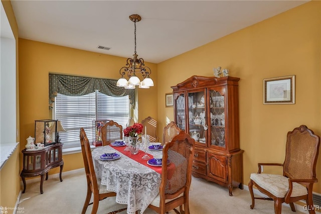 carpeted dining room with a chandelier