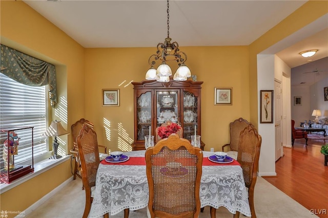 dining area featuring hardwood / wood-style floors and an inviting chandelier