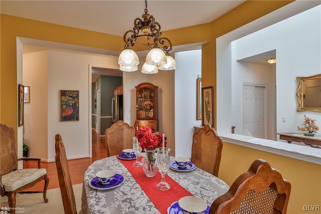 dining space featuring hardwood / wood-style floors and a notable chandelier