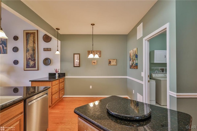 kitchen with dark stone countertops, pendant lighting, stainless steel dishwasher, and light hardwood / wood-style floors