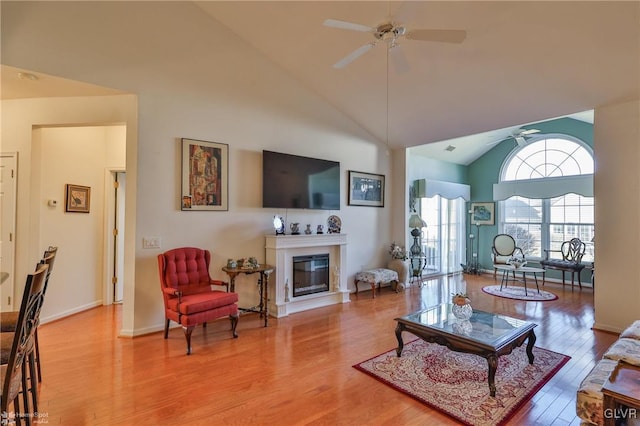 living room featuring hardwood / wood-style flooring, ceiling fan, and high vaulted ceiling