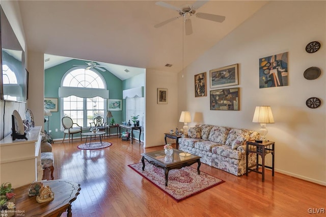 living room featuring hardwood / wood-style floors, ceiling fan, and high vaulted ceiling