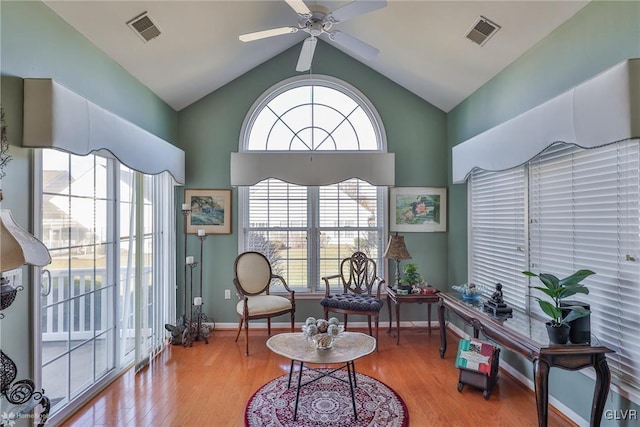 living area with light hardwood / wood-style floors, vaulted ceiling, and ceiling fan