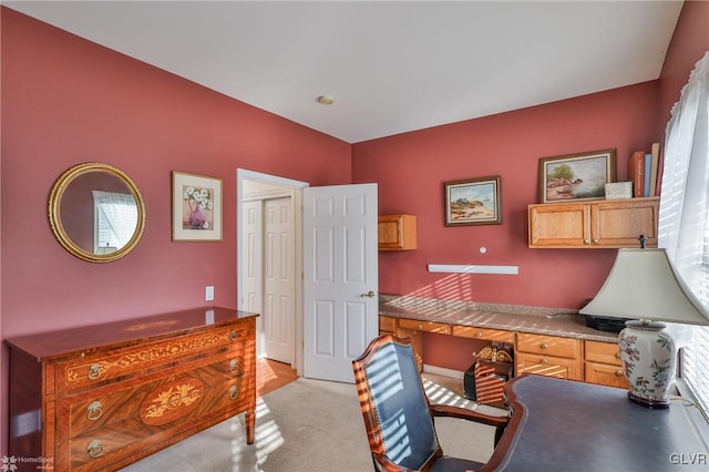 carpeted home office with built in desk